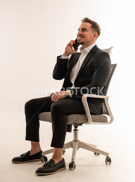 Saudi Businessman Talking on Smartphone in Office Chair