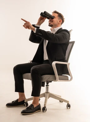 رجل أعمال سعودي مع منظار على كرسي مكتب