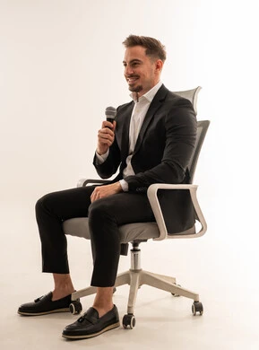 Saudi Businessman Speaking with Microphone in Office Chair