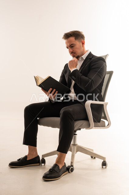 Saudi Businessman Reading a Book in Office Chair
