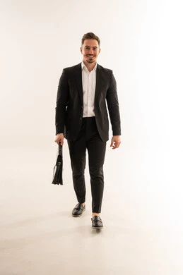 رجل أعمال سعودي يرتدي بدلة رسمية ويمشي مع حقيبة عمل