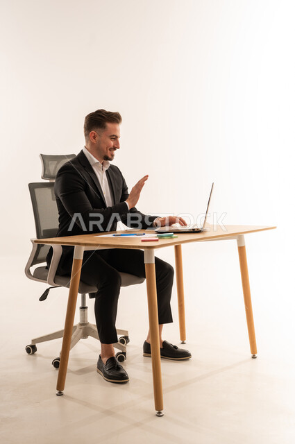 رجل أعمال سعودي يلوح أثناء مكالمة فيديو