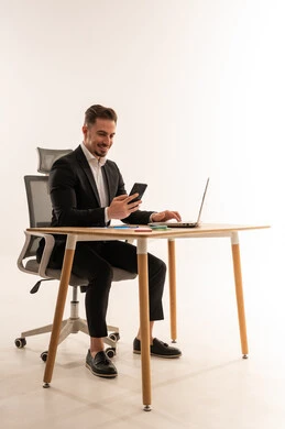 رجل أعمال سعودي يعمل على مكتب مع كمبيوتر محمول