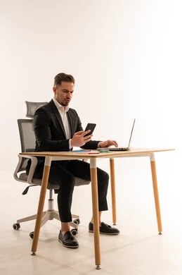 رجل أعمال سعودي على مكتب مع كمبيوتر محمول وهاتف