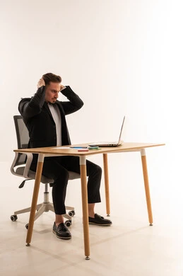 رجل أعمال سعودي يشعر بالإجهاد والضغط أمام اللابتوب