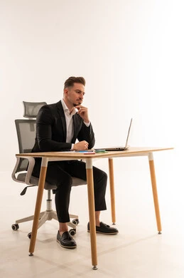 رجل أعمال سعودي يجلس على مكتب مع لابتوب