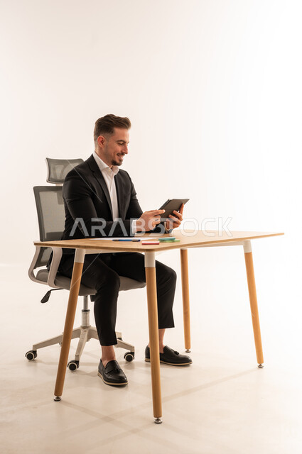 Saudi Businessman Using Digital Tablet at Office Desk