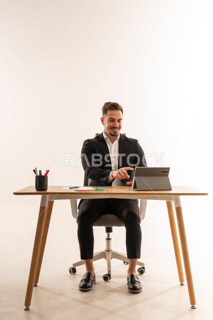 Saudi Businessman Working on Tablet at Office Desk