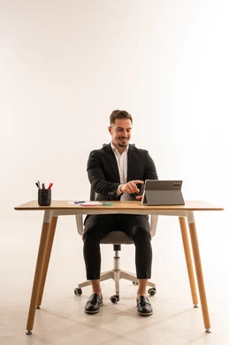 رجل أعمال سعودي يعمل على جهاز لوحي بمكتبه