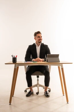 رجل أعمال سعودي يجلس على مكتب مع جهاز لوحي