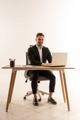 رجل أعمال سعودي على مكتب مع لابتوب خلفية بيضاء