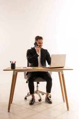 رجل أعمال سعودي يستخدم الكمبيوتر المحمول والهاتف