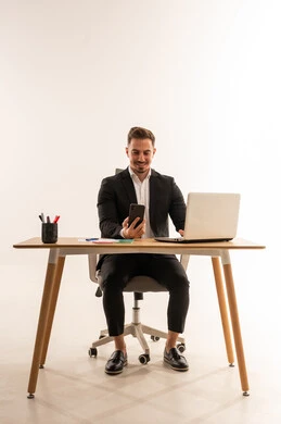 رجل أعمال سعودي يستخدم الهاتف الذكي في مكتب عصري