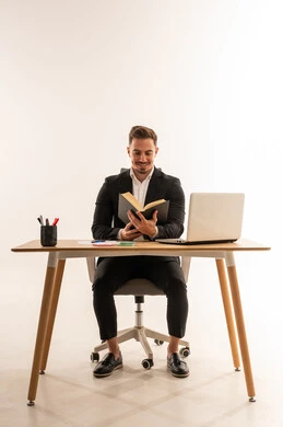 رجل أعمال سعودي يقرأ كتاباً في مكتبه