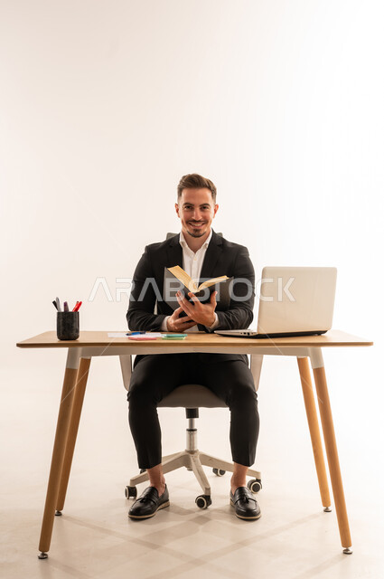 Saudi Businessman Reading a Book at Office Desk