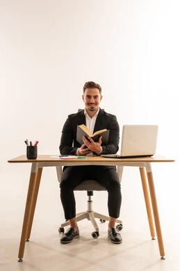 رجل أعمال سعودي يقرأ كتاباً على مكتبه