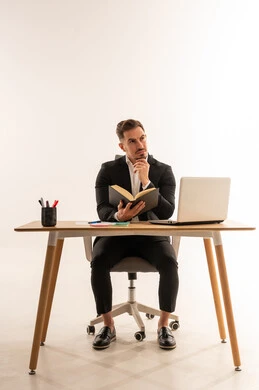 رجل أعمال سعودي على مكتب العمل يفكر مع كتاب