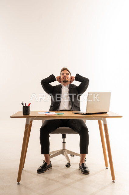 رجل أعمال سعودي يسترخي على مكتب العمل