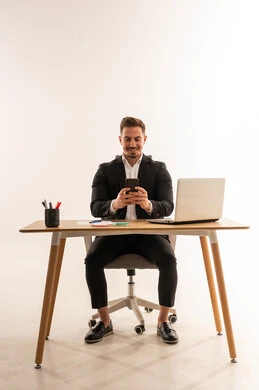 رجل أعمال سعودي يستخدم الهاتف الذكي في المكتب