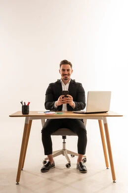 Saudi Businessman at Office Desk with Smartphone