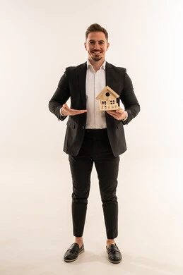 رجل أعمال سعودي يحمل نموذج منزل على خلفية بيضاء