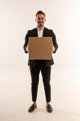 رجل أعمال سعودي يحمل صندوق توصيل على خلفية بيضاء