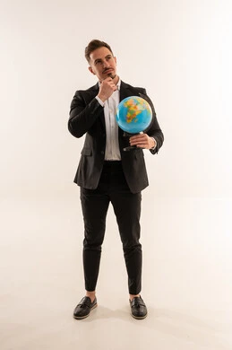 رجل أعمال سعودي يفكر ويحمل مجسم الكرة الأرضية