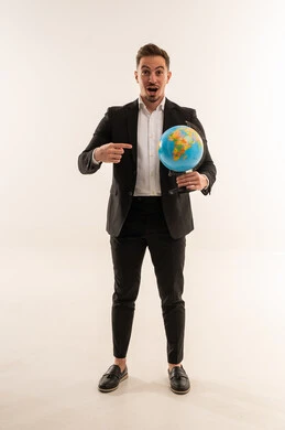 رجل أعمال سعودي يحمل كرة أرضية على خلفية بيضاء