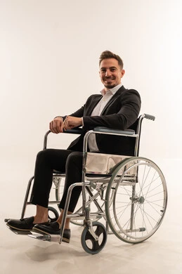 رجل أعمال سعودي على كرسي متحرك بخلفية بيضاء