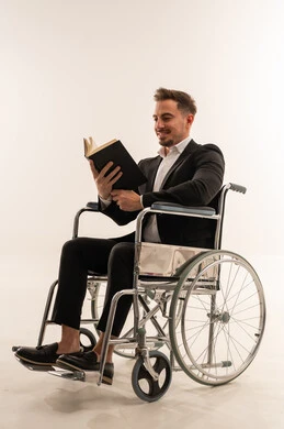 رجل سعودي على كرسي متحرك يقرأ كتاباً في الاستوديو