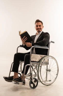 رجل أعمال سعودي على كرسي متحرك يقرأ كتاباً