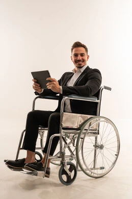 رجل أعمال سعودي على كرسي متحرك يحمل جهازاً لوحياً