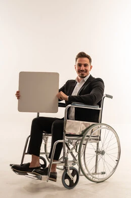 رجل أعمال سعودي على كرسي متحرك يحمل لوحة فارغة