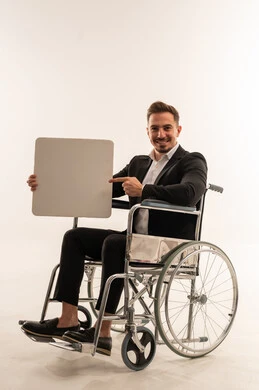 رجل أعمال سعودي على كرسي متحرك يحمل لوحة فارغة