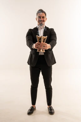 رجل سعودي بملابس رسمية يحمل مبخرة تقليدية