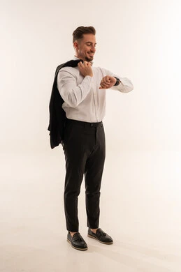 رجل أعمال سعودي يتفقد ساعة يده بخلفية بيضاء