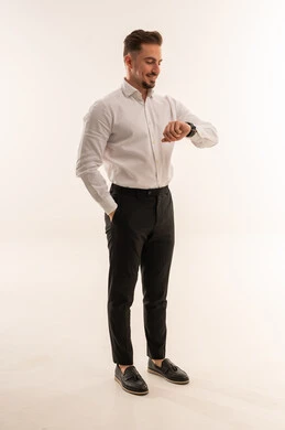 رجل أعمال سعودي يتفقد ساعة يده بخلفية بيضاء