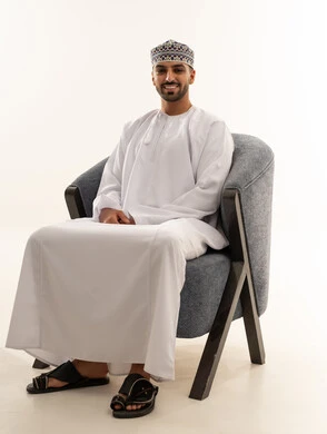 Omani Man in Traditional Dishdasha Sitting in Chair