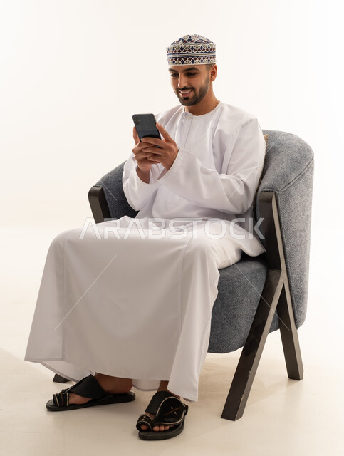 Omani Man in Traditional Dress Using Smartphone