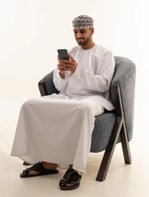 Omani Man in Traditional Dress Using Smartphone