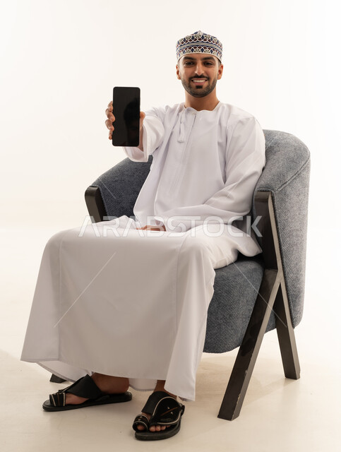 Omani Man in Traditional Dress Holding Smartphone
