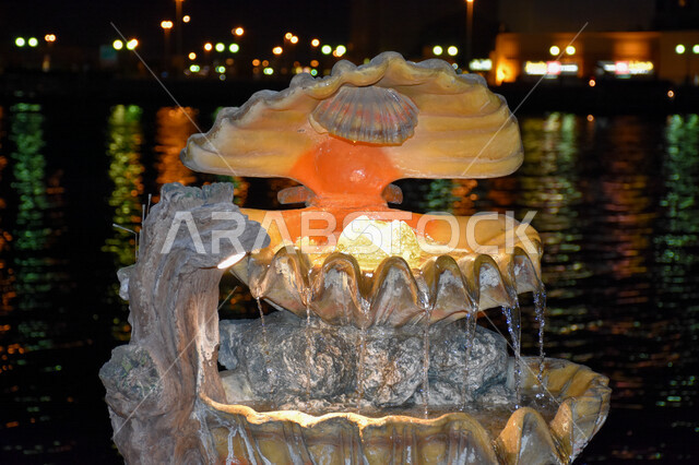 صورة ليلية لصدفة لؤلؤ كبيرة على شكل نافورة في مدينة دبي، معالم الإمارات ، السياحة في الإمارات. 