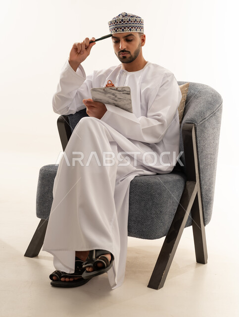 رجل عماني بالزي التقليدي يفكر في استوديو