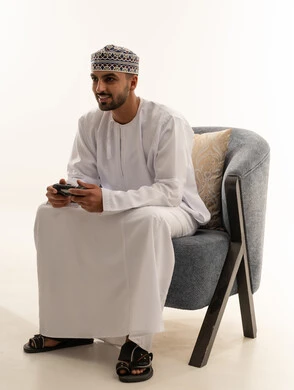 Omani Man Playing Video Games in Traditional Dress