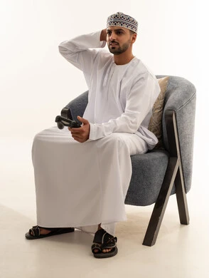 Omani Man Playing Video Games in Traditional Dishdasha