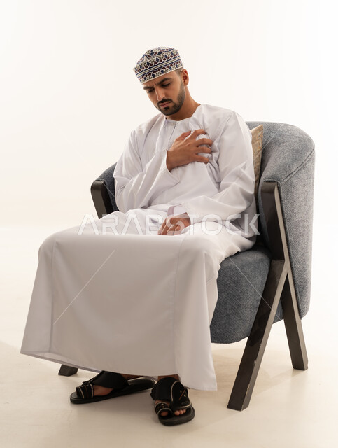 رجل عماني بالزي التقليدي يشعر بألم في الصدر