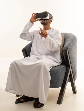 رجل عماني يرتدي نظارة الواقع الافتراضي بالزي التقليدي