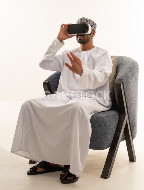 Omani Man Wearing VR Headset in White Dishdasha