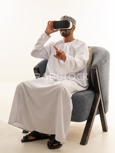 Omani Man Using VR Headset in Traditional Dishdasha
