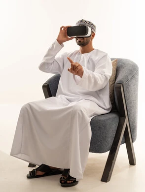 Omani Man Using VR Headset in Traditional Dishdasha